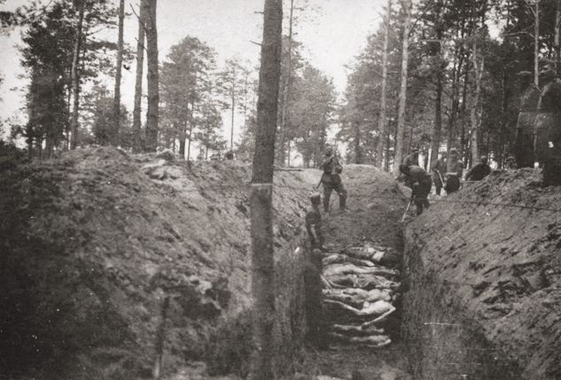 A mass grave in which the corpses of Soviet POWs are being buried